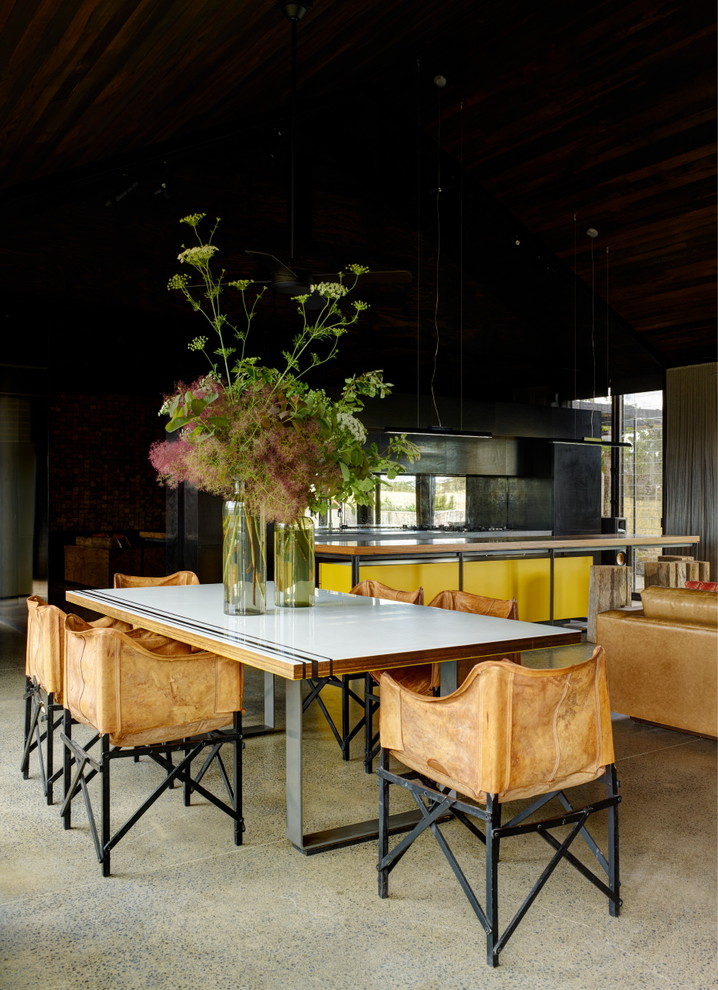 Idéer för mellanstora funkis kök med matplatser, med svarta väggar, betonggolv och en spiselkrans i metall