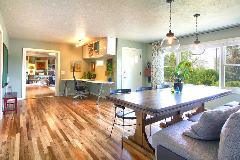 Idées déco pour une petite salle à manger moderne avec un mur bleu et un sol en bois brun.