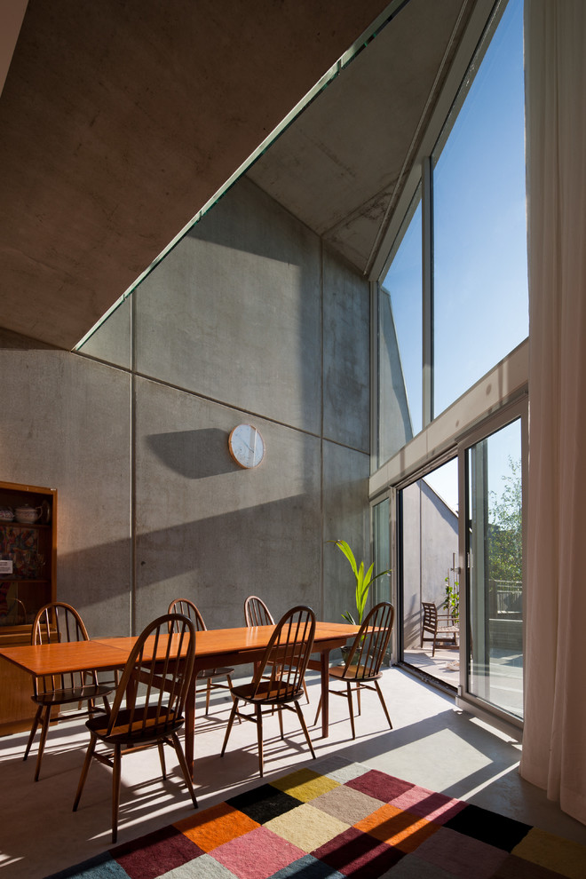 Aménagement d'une salle à manger contemporaine avec un mur gris.