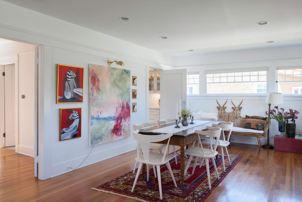 Immagine di una sala da pranzo tradizionale con pareti bianche, pavimento in legno massello medio e pavimento marrone