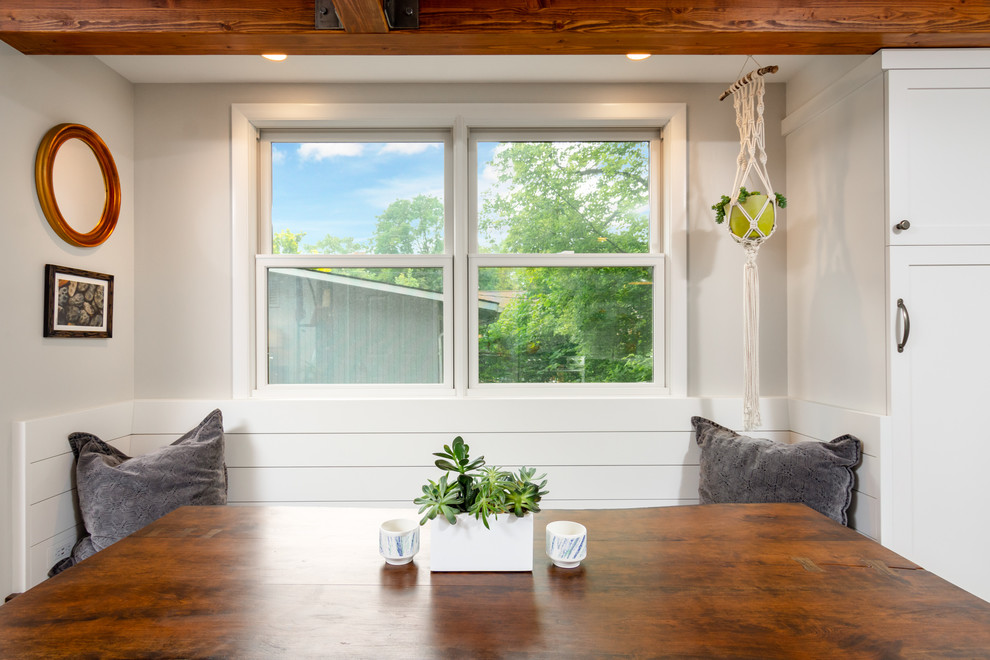 Immagine di una piccola sala da pranzo aperta verso la cucina design con pareti grigie, nessun camino, pavimento marrone e pavimento in legno massello medio