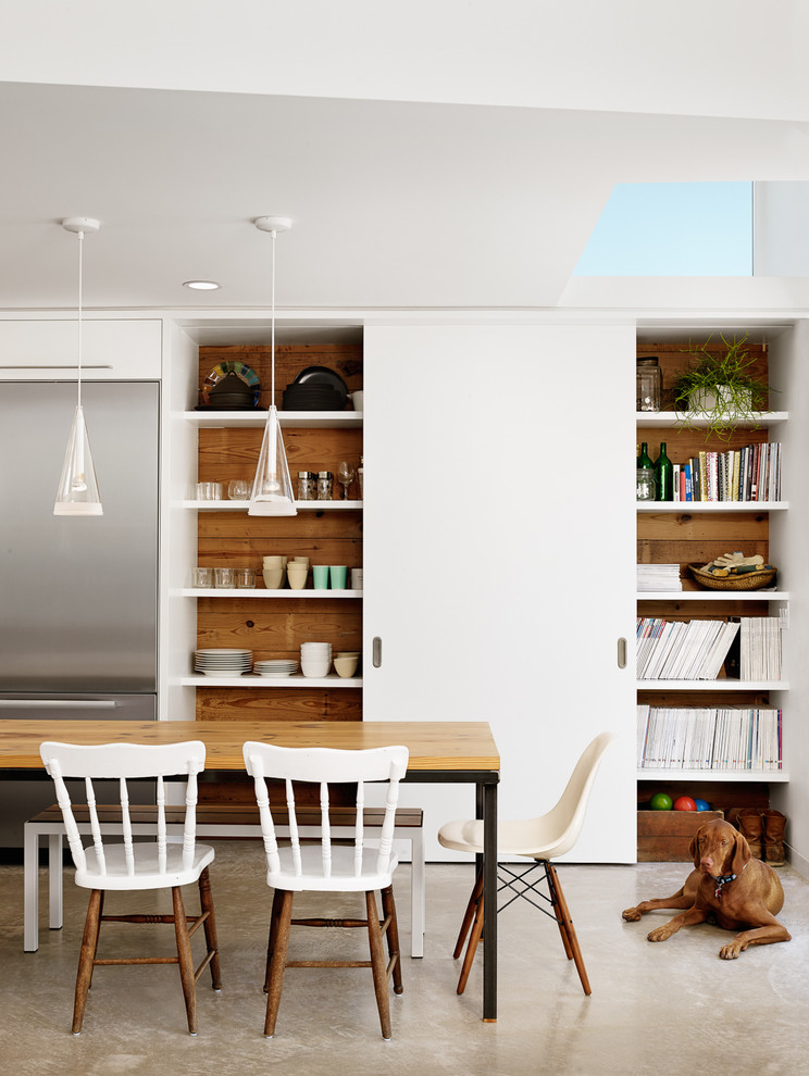 Ispirazione per una sala da pranzo aperta verso la cucina design con pareti bianche