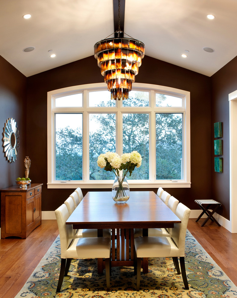 На фото: столовая в современном стиле с коричневыми стенами и темным паркетным полом