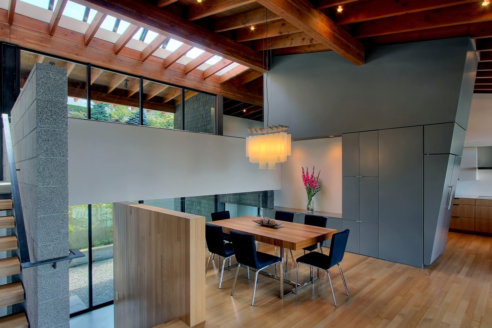 Immagine di una sala da pranzo moderna con pareti grigie e pavimento in legno massello medio