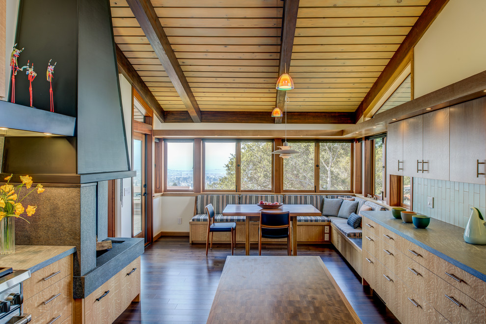 Mittelgroße Retro Wohnküche mit brauner Wandfarbe, dunklem Holzboden, Kaminumrandung aus Beton und braunem Boden in San Francisco