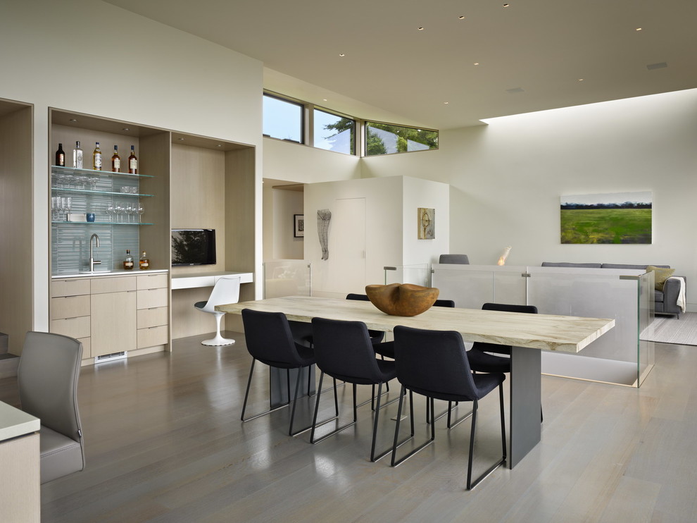 Cette image montre une salle à manger ouverte sur le salon minimaliste.