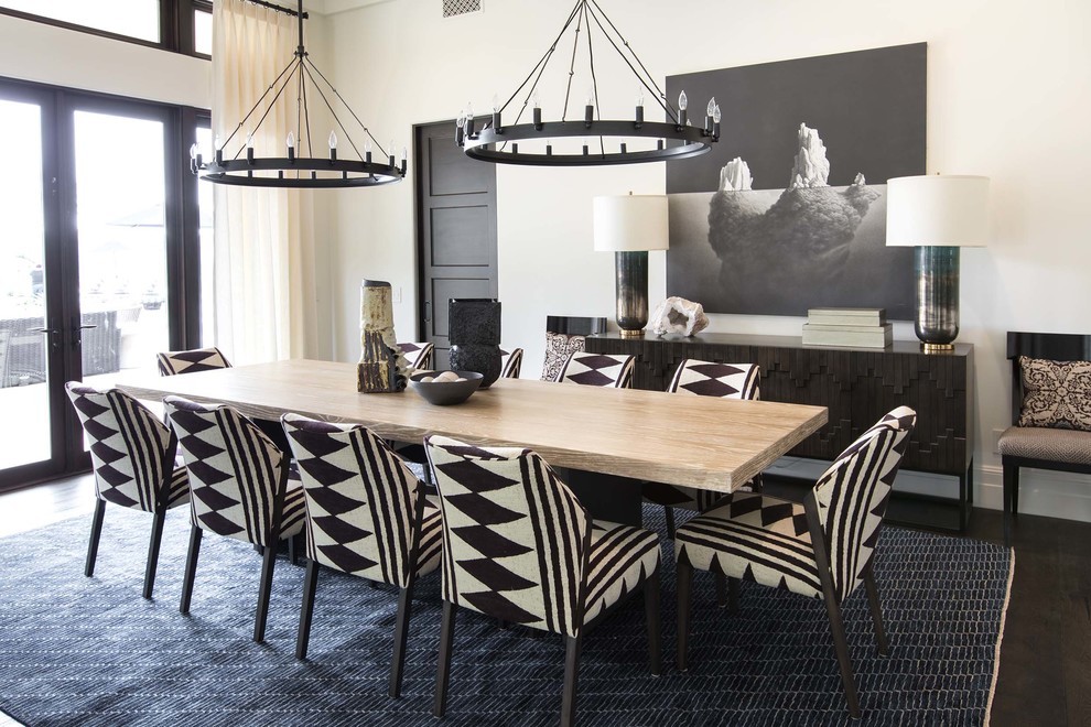 Large mediterranean open plan dining room in Orange County with dark hardwood flooring, beige walls, no fireplace, brown floors and feature lighting.