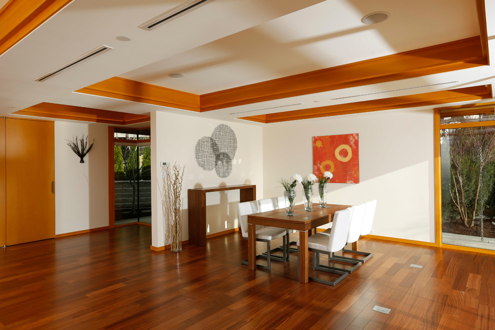 This is an example of a large contemporary kitchen/dining room in Vancouver with medium hardwood flooring, no fireplace, white walls and brown floors.