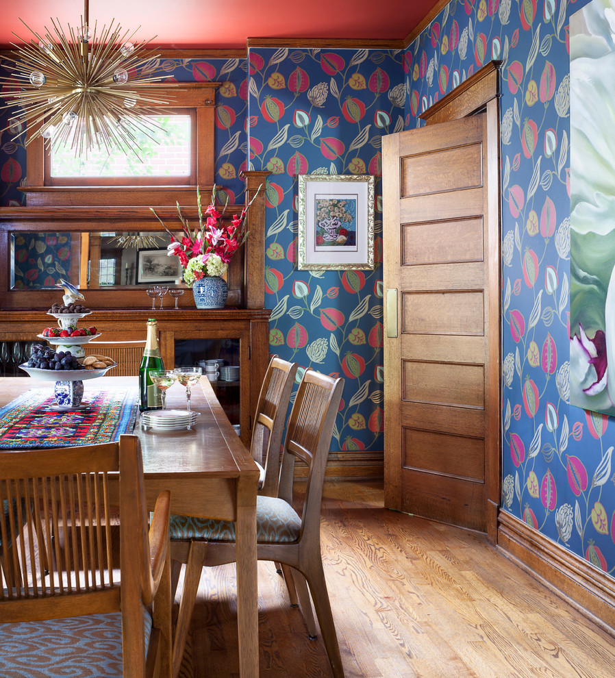 Immagine di una sala da pranzo eclettica chiusa con pareti blu, pavimento in legno massello medio e pavimento marrone