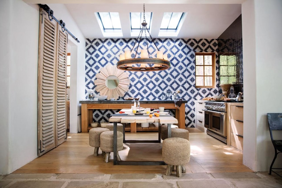 Cette photo montre une salle à manger ouverte sur la cuisine bord de mer avec un mur bleu et un sol en bois brun.