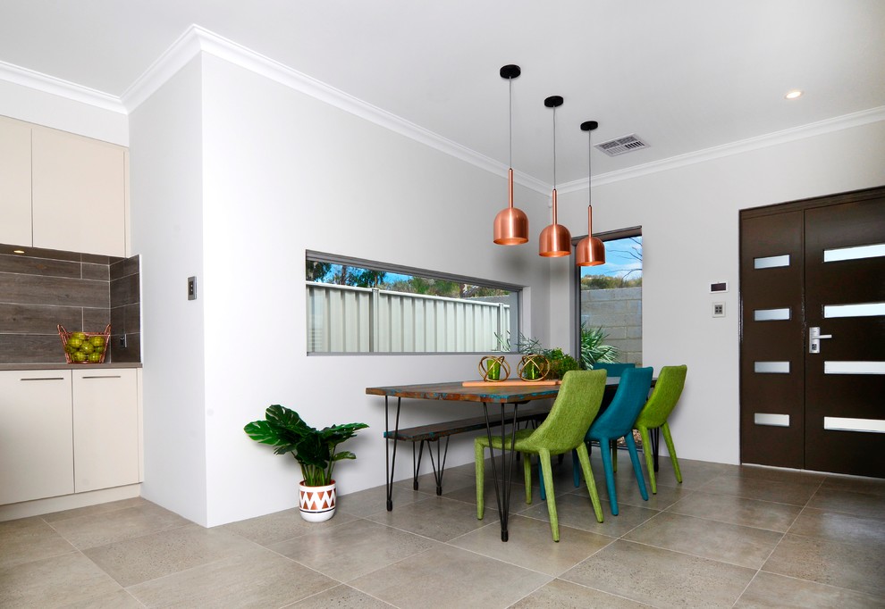 Ispirazione per una sala da pranzo aperta verso la cucina eclettica di medie dimensioni con pareti bianche e pavimento in cemento