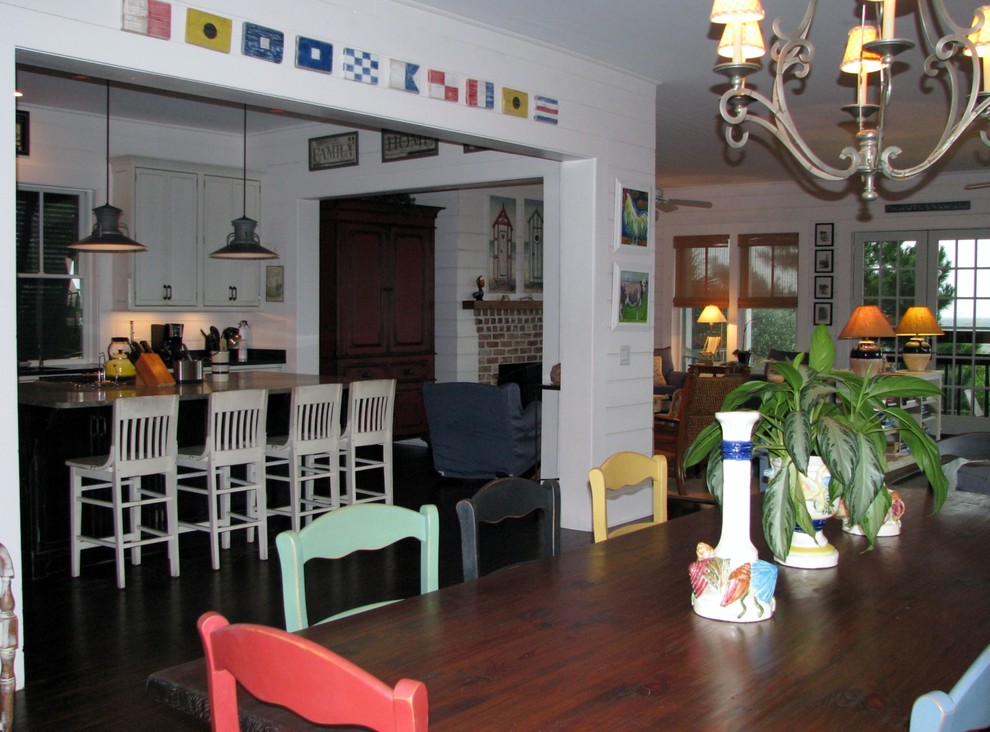 Offenes, Großes Shabby-Style Esszimmer mit weißer Wandfarbe, dunklem Holzboden, Kamin und Kaminumrandung aus Backstein in Charleston