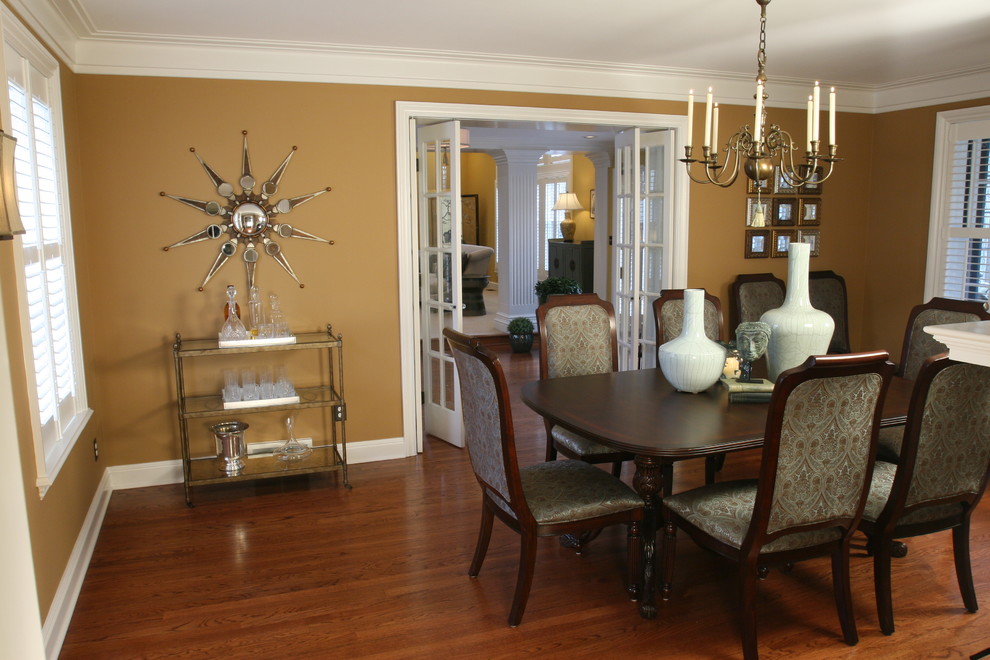 Exemple d'une salle à manger ouverte sur la cuisine chic de taille moyenne avec un mur beige, parquet foncé, une cheminée standard, un manteau de cheminée en brique et un sol marron.