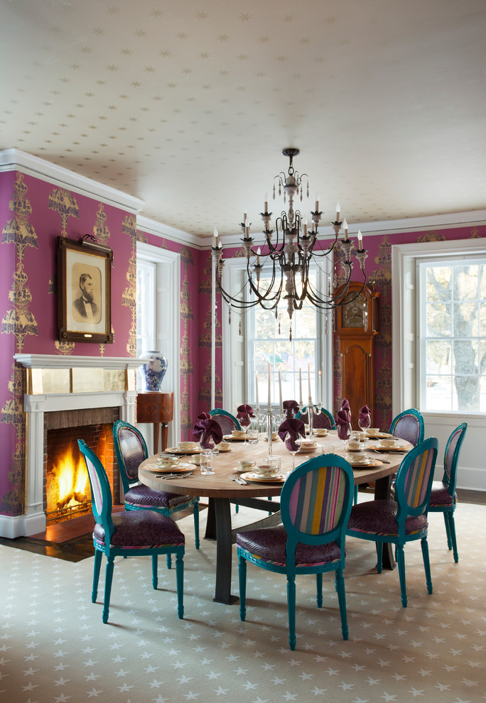 Cette photo montre une salle à manger tendance avec une cheminée standard, un manteau de cheminée en brique et un mur rose.