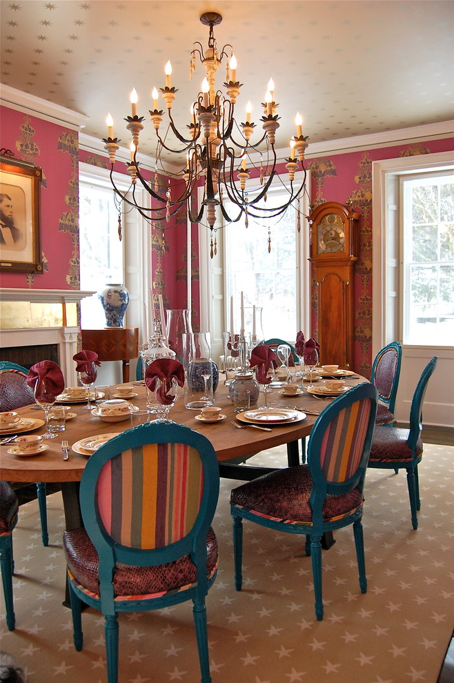 Esempio di una sala da pranzo design con parquet scuro, camino classico e pareti rosa