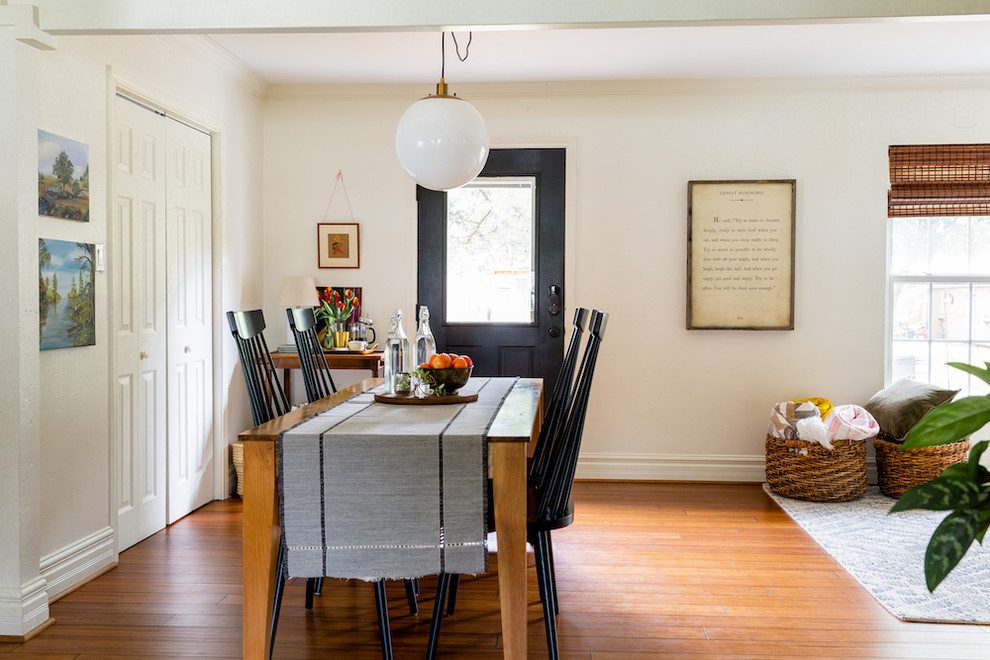 Aménagement d'une petite salle à manger ouverte sur la cuisine éclectique avec un mur blanc, un sol en bois brun, aucune cheminée et un sol marron.