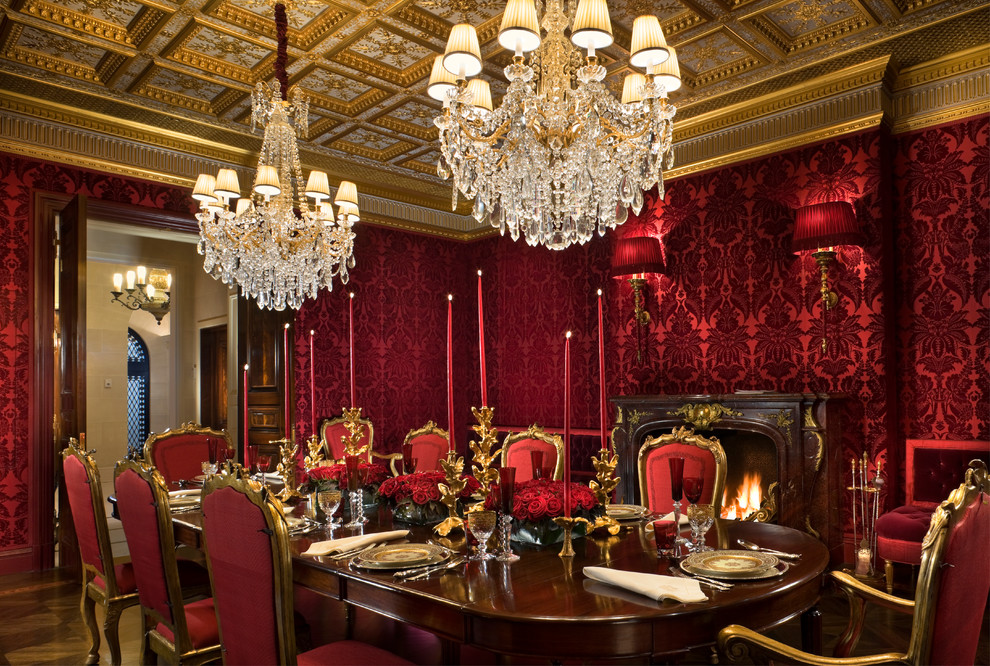 Immagine di una grande sala da pranzo tradizionale chiusa con pareti rosse, pavimento in legno massello medio, camino classico e cornice del camino in legno