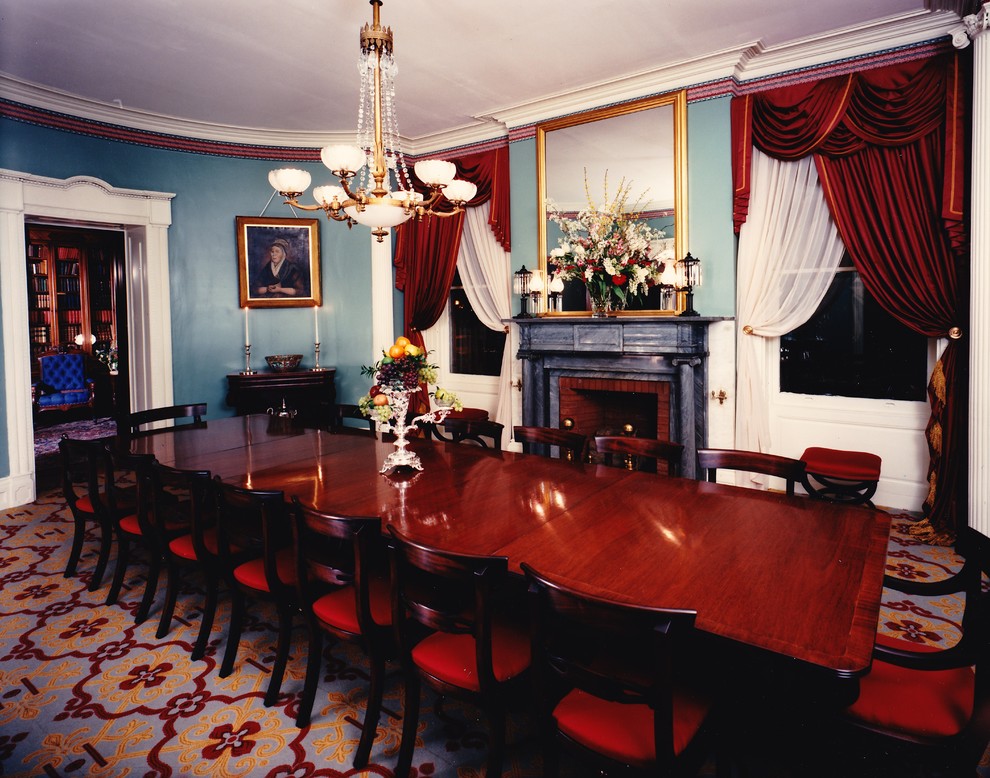 Пример оригинального дизайна: отдельная столовая в викторианском стиле с синими стенами, ковровым покрытием, стандартным камином и фасадом камина из камня