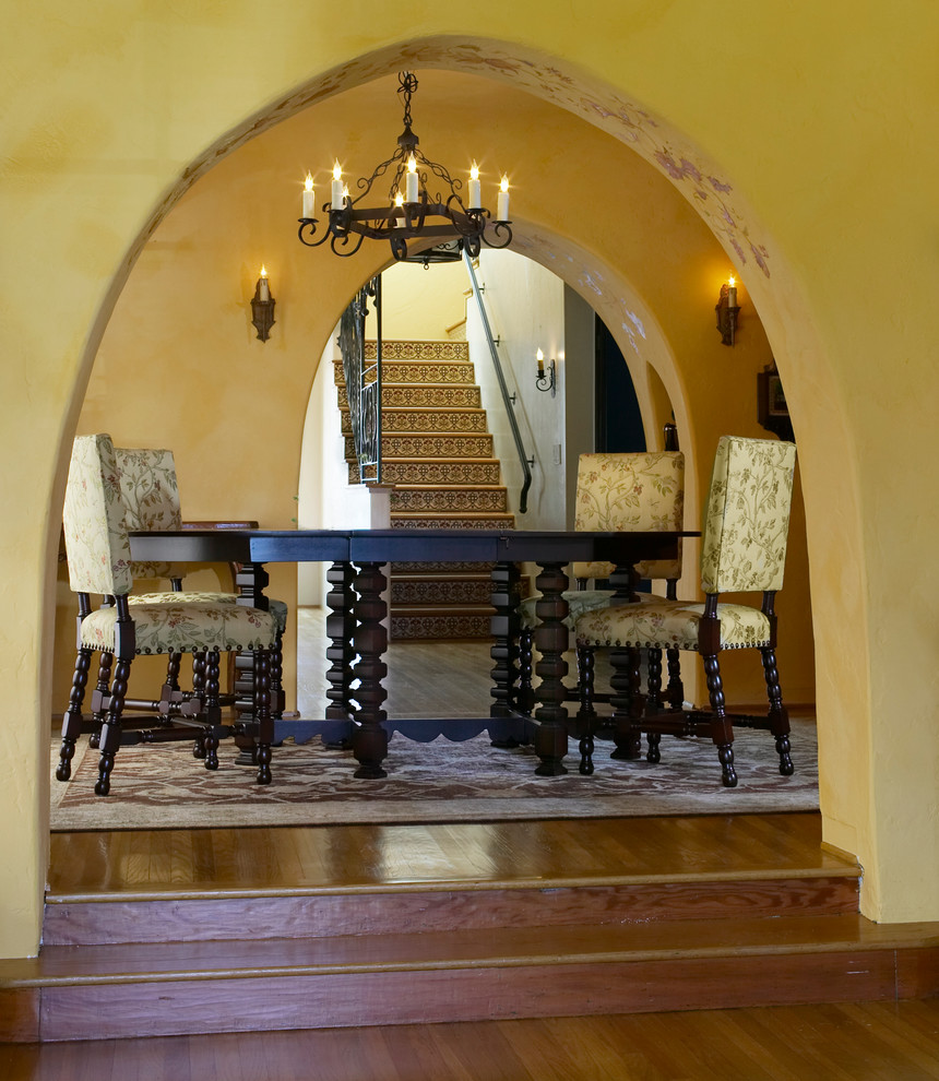 Esempio di una sala da pranzo mediterranea con pareti gialle e pavimento in legno massello medio