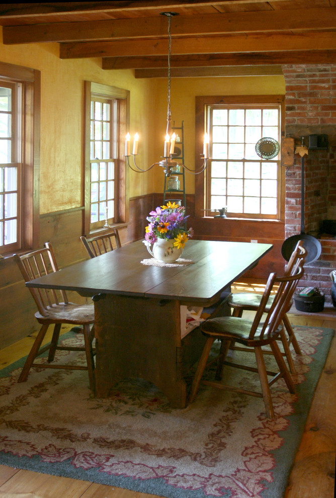 Foto de comedor de estilo de casa de campo con paredes amarillas y suelo de madera clara