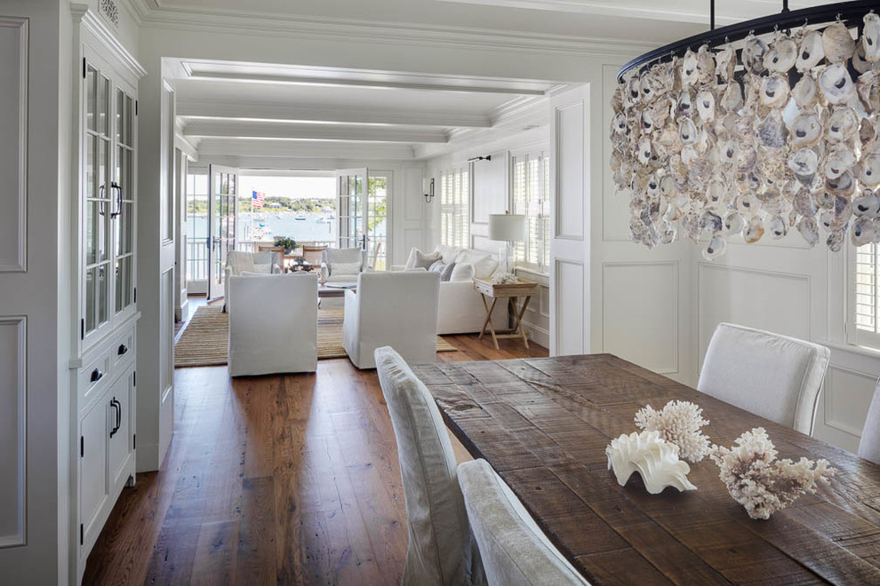 Inspiration for a large coastal open plan dining room in Boston with white walls, medium hardwood flooring, no fireplace and feature lighting.