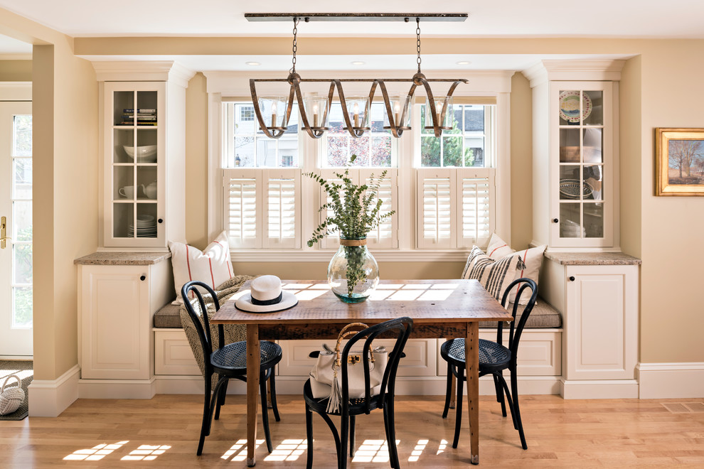 Immagine di una sala da pranzo aperta verso la cucina classica con pareti beige, parquet chiaro e pavimento marrone