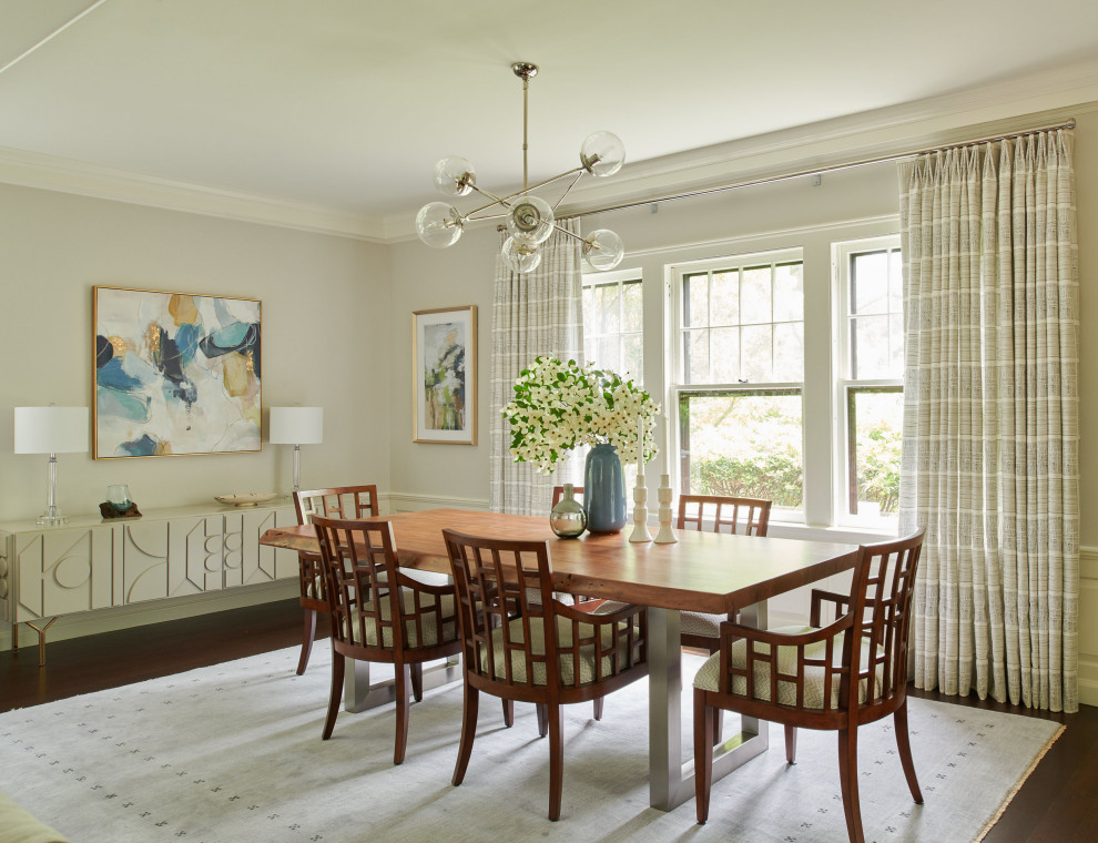 Cette image montre une salle à manger ouverte sur le salon traditionnelle avec parquet foncé, un sol marron, un mur gris et boiseries.
