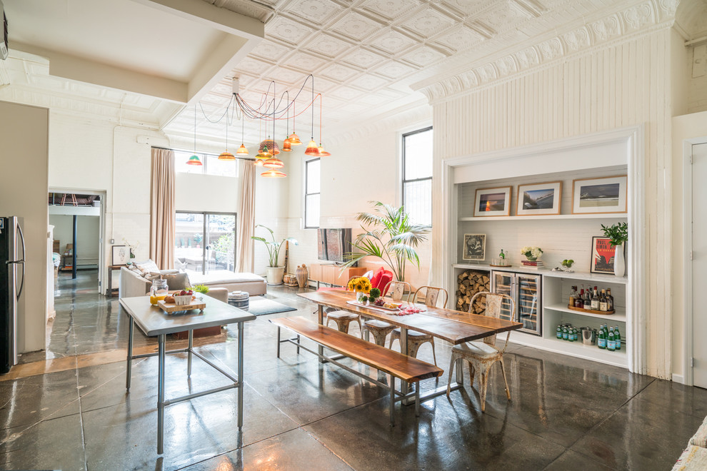 Photo of a large eclectic open plan dining room in New York with white walls, concrete flooring and grey floors.