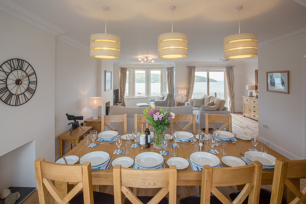 Esempio di una sala da pranzo costiera con pareti bianche, parquet chiaro e pavimento blu