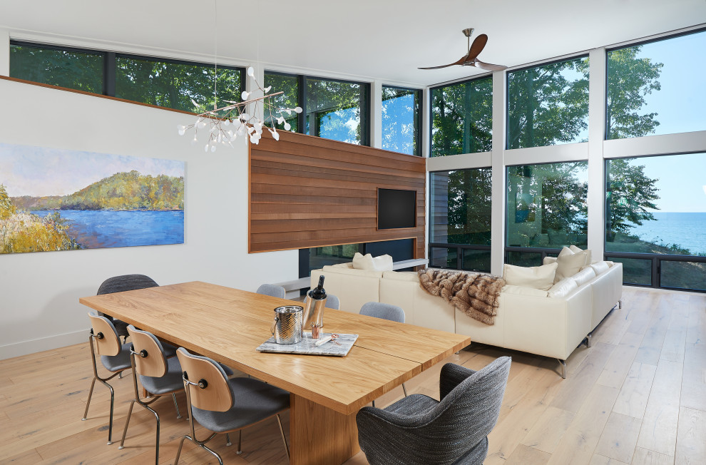 Ejemplo de comedor contemporáneo abierto con paredes blancas, suelo de madera en tonos medios, chimenea lineal, suelo marrón y madera