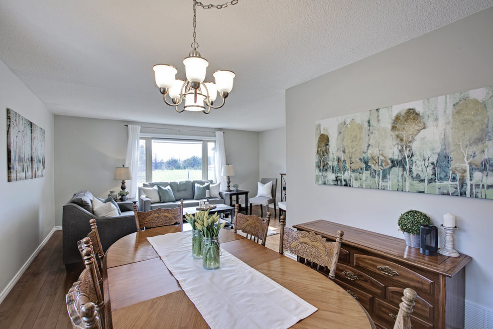 Small classic kitchen/dining room in Toronto with grey walls, medium hardwood flooring, no fireplace and brown floors.