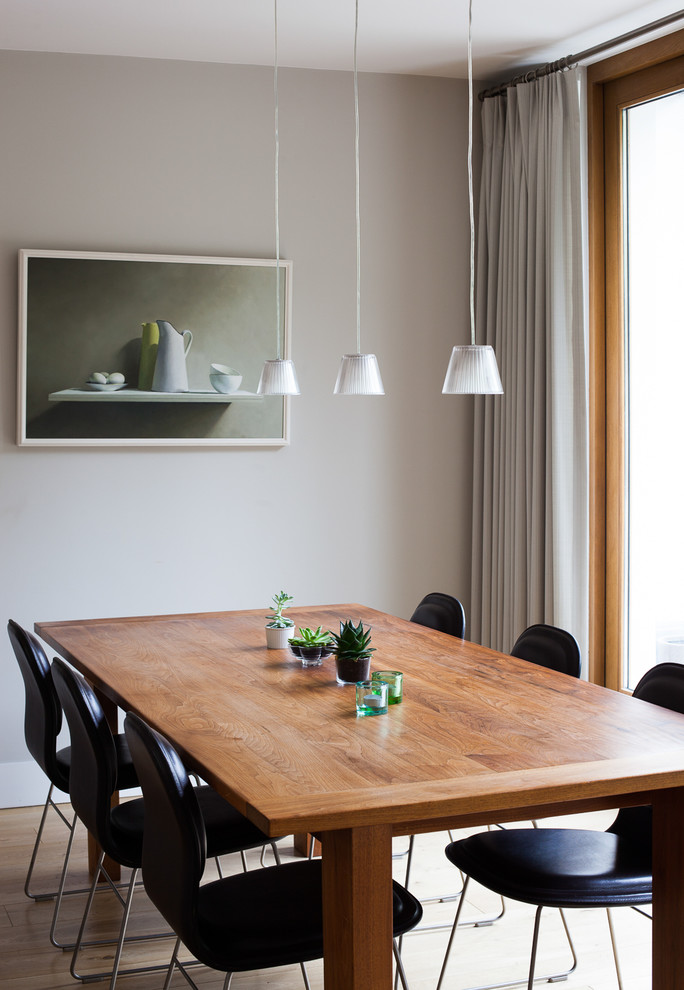 Small classic open plan dining room in London with grey walls, light hardwood flooring and brown floors.