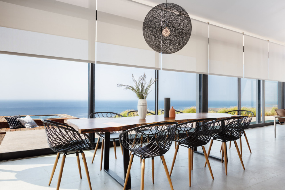 Esempio di una sala da pranzo aperta verso il soggiorno minimalista di medie dimensioni con pavimento in cemento e pavimento grigio