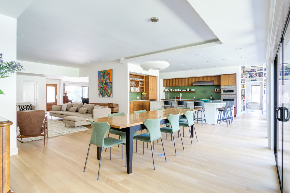 Foto di una grande sala da pranzo aperta verso il soggiorno contemporanea con pareti bianche, parquet chiaro e pavimento beige