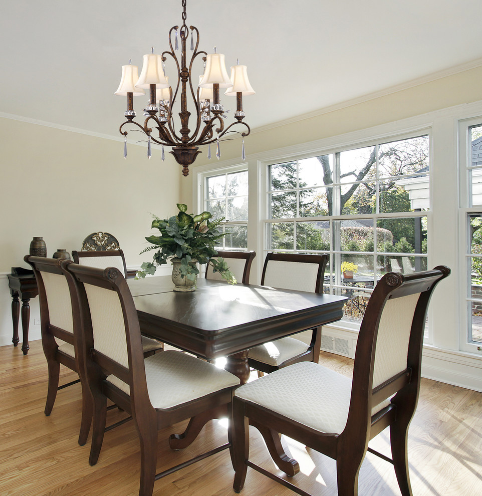 This is an example of a medium sized traditional enclosed dining room in New York with beige walls and medium hardwood flooring.