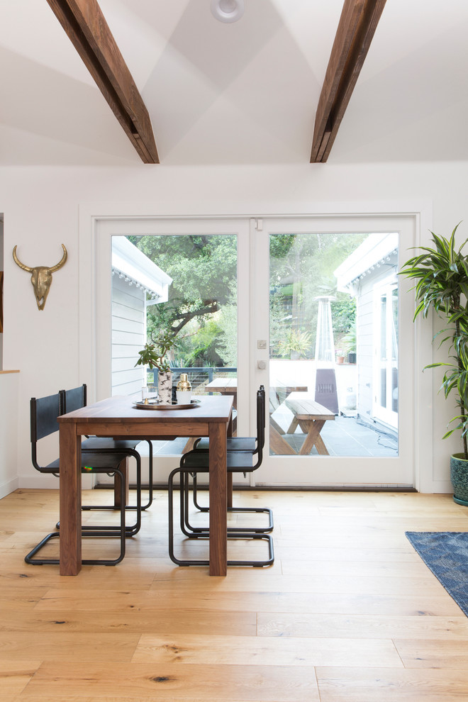 Aménagement d'une salle à manger ouverte sur le salon classique avec un mur blanc, parquet clair et un sol beige.