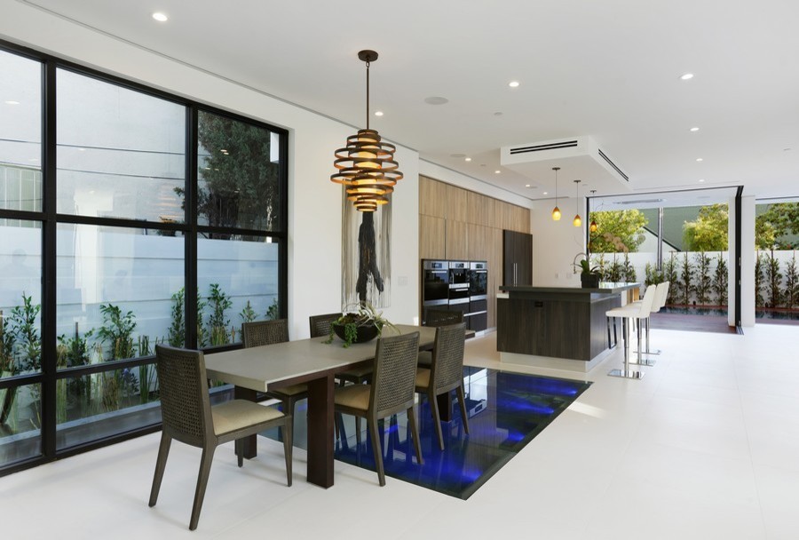 Immagine di una sala da pranzo aperta verso la cucina moderna di medie dimensioni con pareti bianche, pavimento in cemento, nessun camino e pavimento bianco