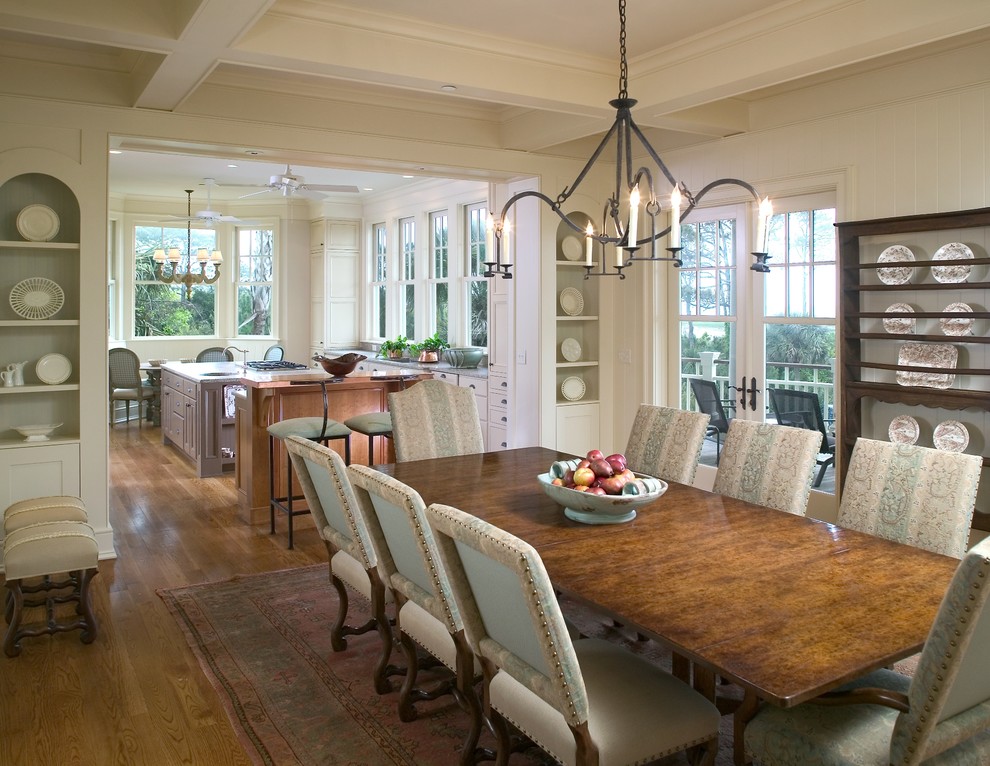 Immagine di una grande sala da pranzo aperta verso la cucina classica con pareti bianche, pavimento in legno massello medio e nessun camino