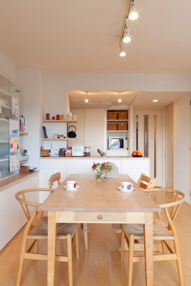 Стильный дизайн: кухня-столовая среднего размера с белыми стенами и паркетным полом среднего тона без камина - последний тренд