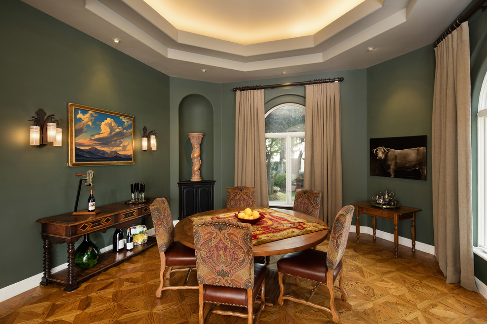 Aménagement d'une grande salle à manger ouverte sur la cuisine campagne avec un mur vert, un sol en bois brun et aucune cheminée.