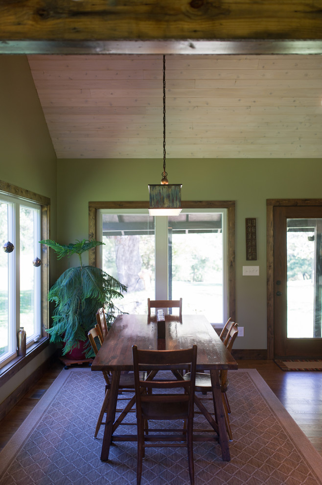 Esempio di una grande sala da pranzo aperta verso il soggiorno stile rurale con pareti verdi e pavimento in legno massello medio
