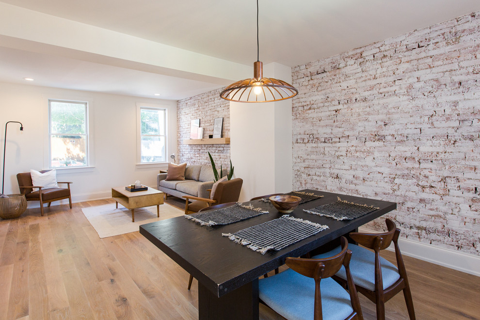 Immagine di una grande sala da pranzo aperta verso il soggiorno minimal con pareti bianche, parquet chiaro e pavimento beige