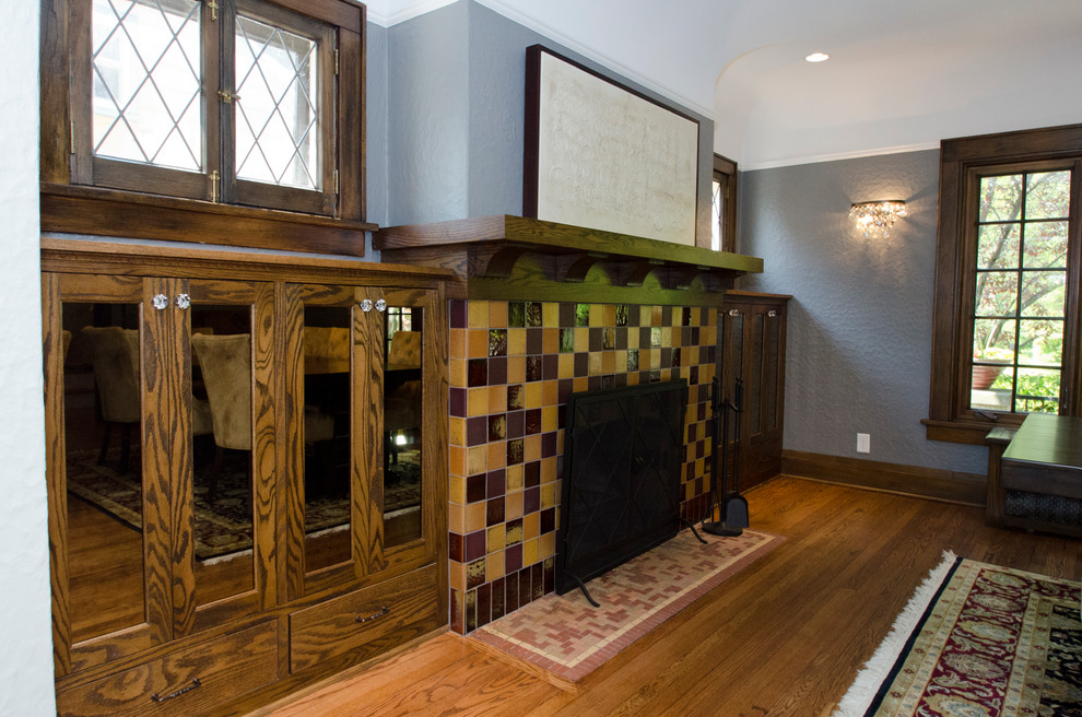 Idées déco pour une salle à manger classique de taille moyenne avec un mur gris, un sol en bois brun, une cheminée standard et un manteau de cheminée en carrelage.