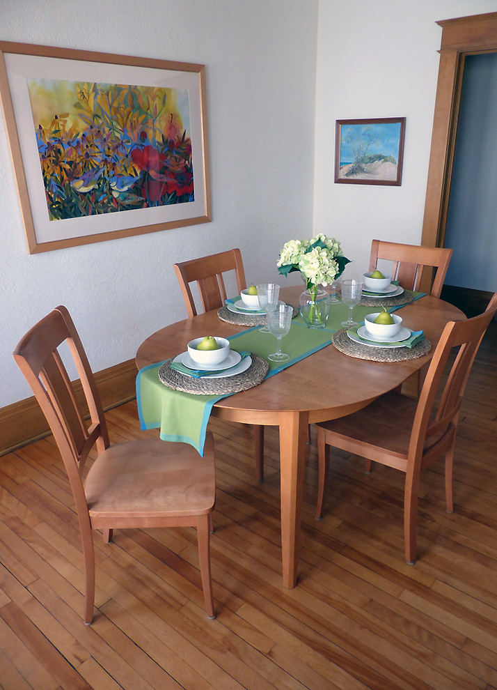 Immagine di una piccola sala da pranzo stile americano chiusa con pareti bianche, pavimento in legno massello medio, nessun camino e pavimento multicolore