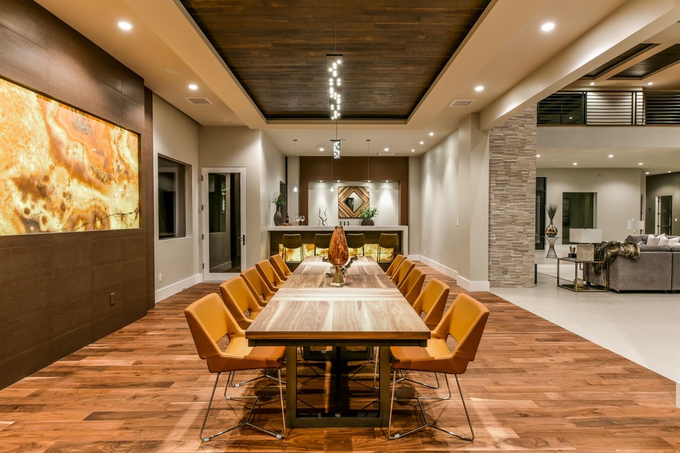 Foto di una sala da pranzo contemporanea con pareti beige, pavimento in legno massello medio e nessun camino