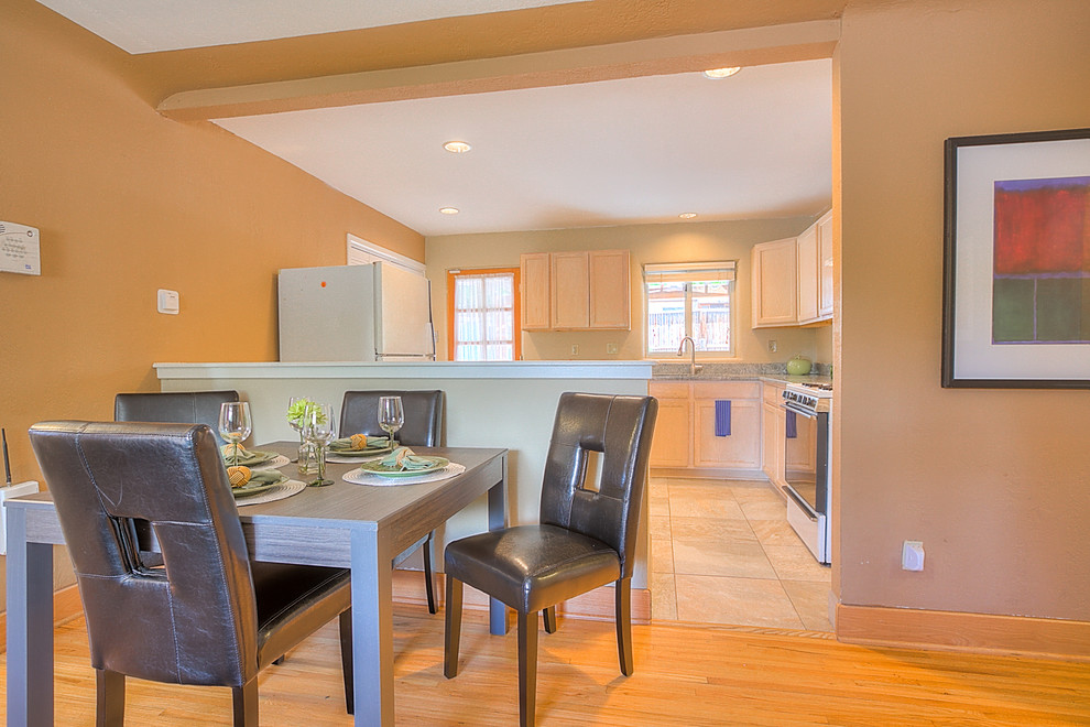 Cette photo montre une petite salle à manger ouverte sur le salon chic avec un mur marron, parquet clair et aucune cheminée.