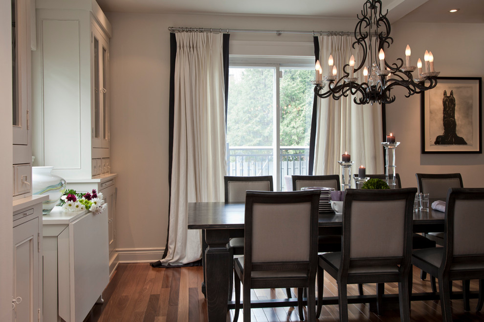 This is an example of a classic dining room in Montreal with white walls and dark hardwood flooring.