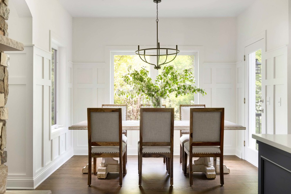Idee per una sala da pranzo aperta verso la cucina di medie dimensioni con pareti bianche, parquet scuro e pavimento marrone