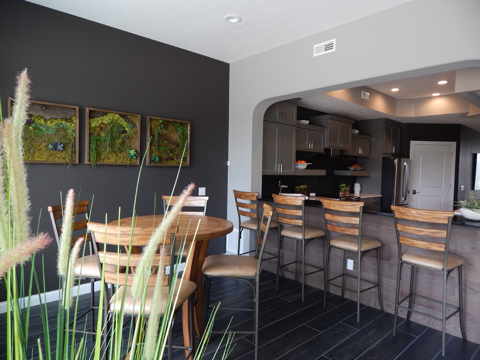 Immagine di una sala da pranzo aperta verso la cucina chic di medie dimensioni con pareti grigie, pavimento in gres porcellanato, nessun camino e pavimento nero