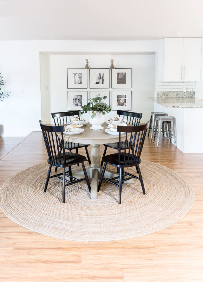 Esempio di una piccola sala da pranzo aperta verso il soggiorno country con pareti bianche, pavimento in laminato e pavimento beige
